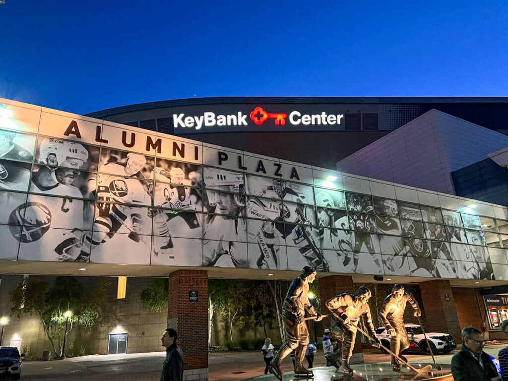 The statue of the French Connection is lit up at night in the Alumni Plaza at KeyBank Center