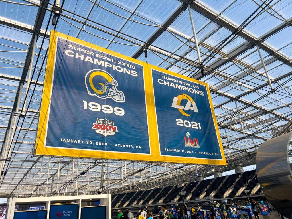 The Los Angeles Rams Super Bowl Championship banners for 1999 and 2021 hang from the rafters in SoFi Stadium.
