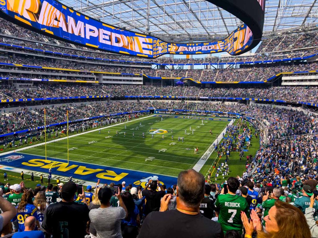 Rams and Eagles fans stand up and cheer their teams during an NFL Game at SoFi Stadium.