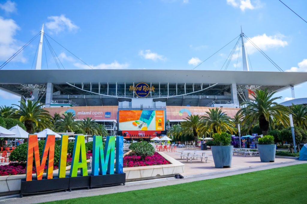 A colorful Miami sign sits in front of hte Hard Rock Stadium, home of the Miami Dolphins NFL team.
