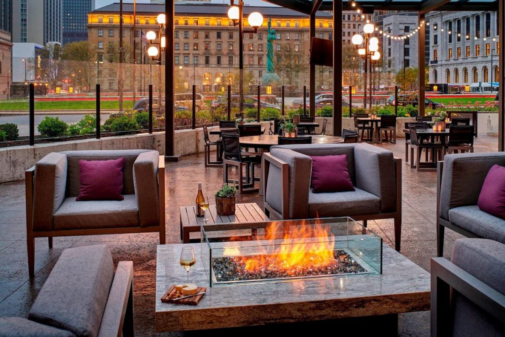 An outdoor lounge with a cozy firepit at the Marriott Downtown at Key Tower hotel near Huntington Bank Field.