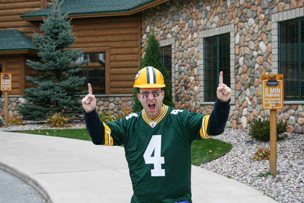 Dan Brewer, owner of UltimateSportsRoadTrip.com wears a Packers hard hat and Brett Favre jersey outside the Tundra Lodge in Green Bay, WI before a Packers home game.