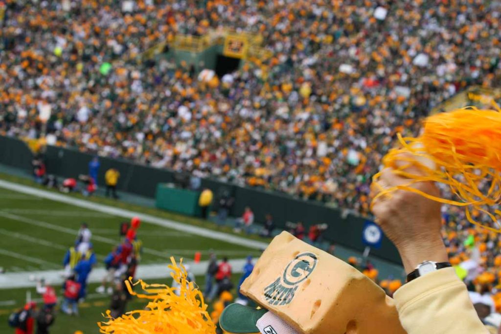 Excited fans cheer for the Green Bay Packers at a home game at Lambeau Field.