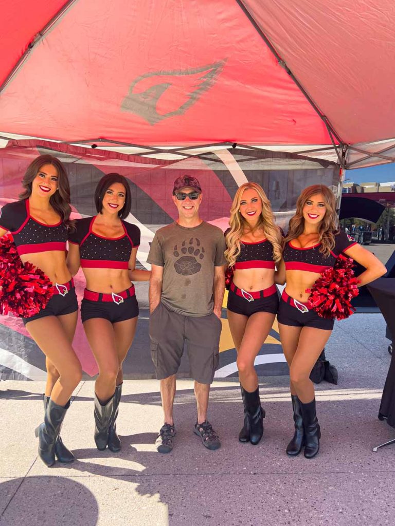 Dan Brewer, owner of UltimateSportsRoadTrip.com, stands with four members of the Arizona Cardinals Cheerleaders squad prior to a home game.