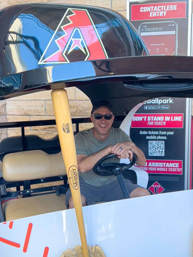 Dan Brewer, owner of UltimateSportsRoadTrip.com, sits in a D-backs Bullpen Cart at Chase Field.