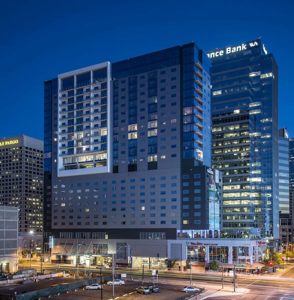 The Kimpton Hotel Palomar Phoenix hotel exterior is lit up at night.